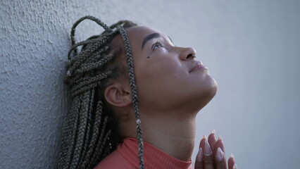 One spiritual young black woman praying to God pleading help and support. A faithful Brazilian...