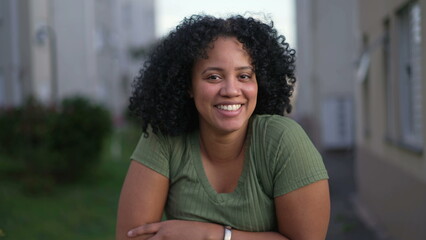 One happy young black latina woman smiling at camera. A Brazilian African American female person with curly hair closeup face - Powered by Adobe
