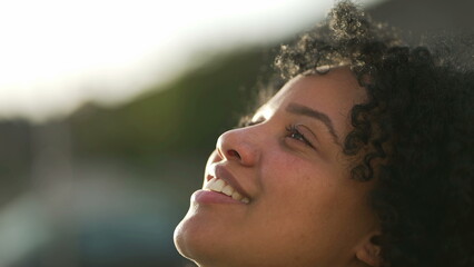 Meditative young woman opening eyes smiling to sky. One contemplative hispanic Brazilian female person in contemplation feeling free - Powered by Adobe