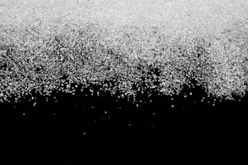 Fototapeta Białe kryształy cukru rozsypane na czarnym tle obraz