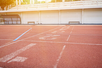 Closeup and crop detail of athletic running track and field with sunbeam