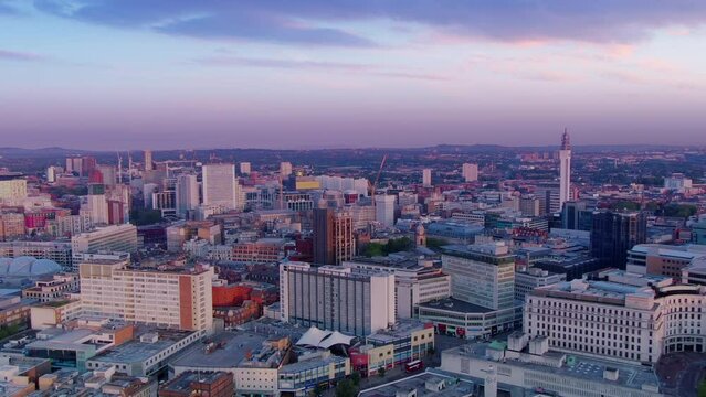 aerial view drone of birmingham city downtown at dawn ,flying backwards rising up colorful sunrise uk england