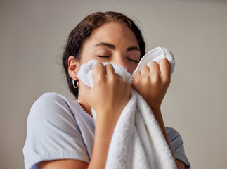 Woman smelling a clean towel after doing laundry at her home, hotel or resort while spring...