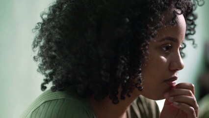 A pensive African American woman closeup face with contemplative emotion pondering solution