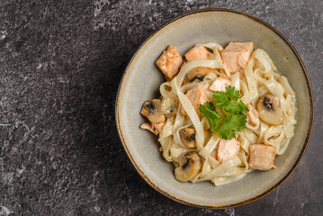 pasta with salmon on a dark background