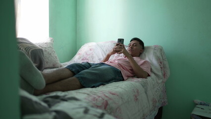 Naklejka premium One hispanic person in bedroom looking at smartphone device. good for transition