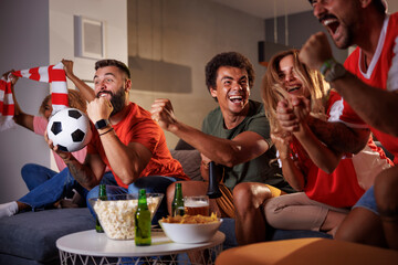 Football fans watching game on TV celebrating their team victory
