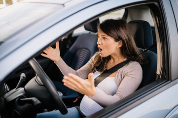 Fototapeta na wymiar Pregnant Caucasian woman with angry face sitting in car