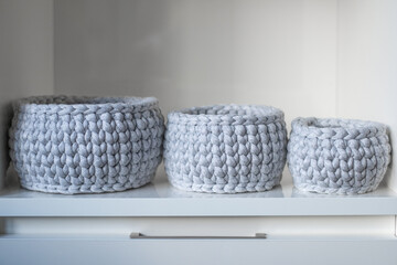 close-up of a beautiful gray crochet baskets, cozy interior, jewellery storage. place for your text. Sustainable, organic lifestyle advertising. Poster for handicrafts. 