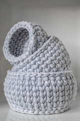 close-up of a beautiful cozy gray crochet baskets, organizers of various small things, storage. a nice hobby in the winter evenings. Sustainable, organic lifestyle advertising. One inside the other