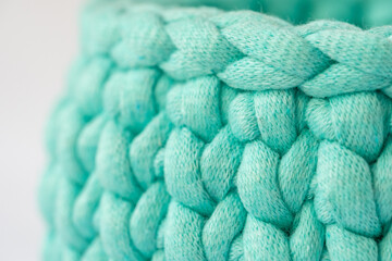 close-up of a beautiful cozy crochet basket, pattern for crocheting, a nice hobby in the winter evenings. Sustainable, organic lifestyle advertising.
