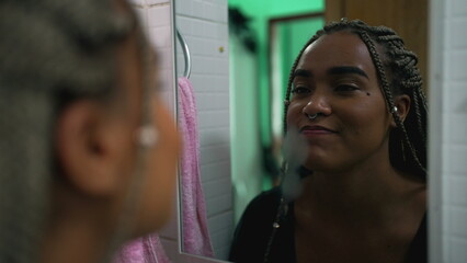 One hopeful black latina girl looking at herself in mirror smiling with HOPE