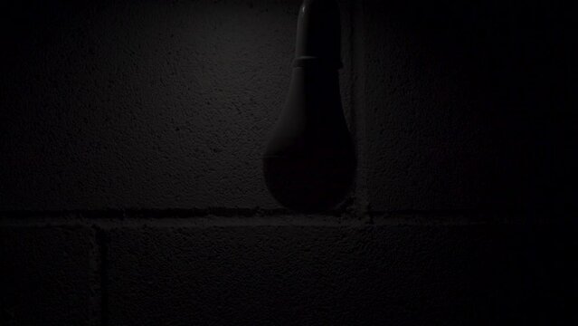 Close up shot of Turn on and turn off a led bulb with copy space in dark room,modern style technology with copy space