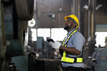 african american male engineer work with digital tablet for check or maintaining heavy metal...