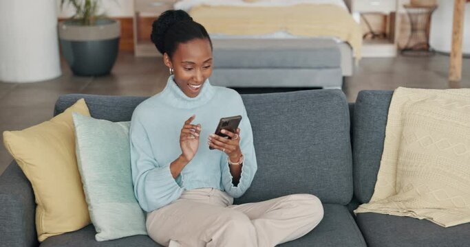 Mobile, good news and happy black woman on a home living room couch reading a text. Dating app, internet and web scroll of a person from New York on a house lounge sofa using technology online