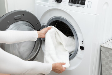 Woman sticking out things from a modern washing machine
