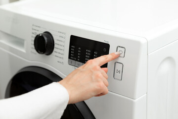 Close-up of a woman's hand that presses and turns off the washing machine