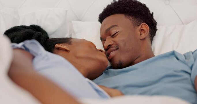 Marriage, love and black couple in bed kissing, intimate and bonding while in bedroom showing love, commitment and romance. Man and woman sharing a kiss and feeling happy in a healthy relationship