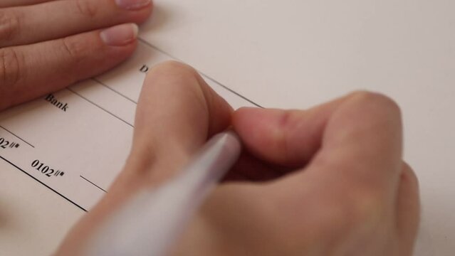 Woman filling and signing a bank check
