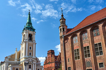 Fototapeta na wymiar The belfry of a baroque church and the turret of the gothic town hall in Torun