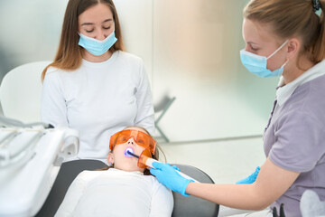 Preteen child getting photopolymer filling in front teeth