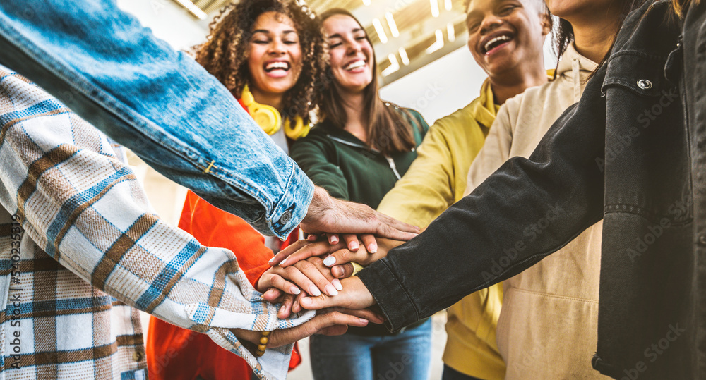 Wall mural multiracial happy young people stacking hands outside