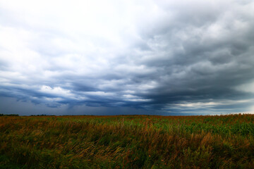 Fototapeta na wymiar cloudscape field hay rolls sky clouds autumn, gloomy weather agriculture