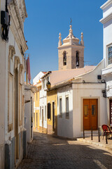 Fototapeta na wymiar Portugal, August 2022: Street and bell tower at Loulé near Faro, Algarve, Portugal
