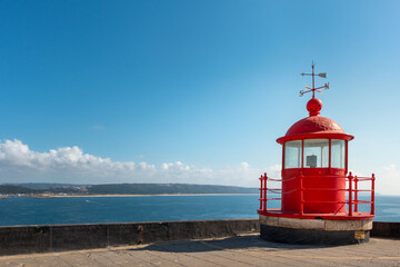 Fototapeta na wymiar Red lighthouse by the sea, Nazaré, Portugal, The Light House, Nazaré