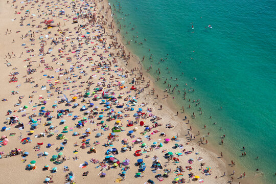Aerial view of a crowded beach from above, praia de Nazaré, Portugal, Europe - Powered by Adobe
