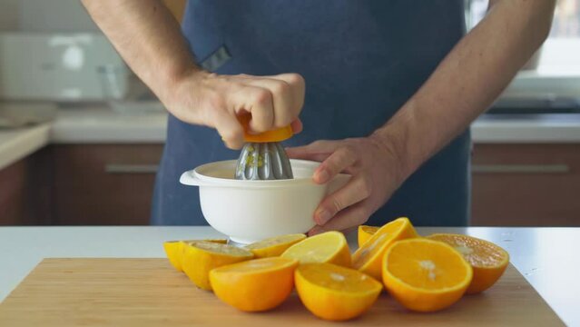 man preparing orange juice in the kitchen