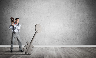 Breaking through access concept with man in room crashing concrete key