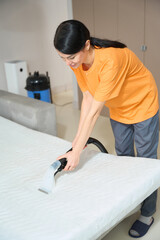 Woman performing general cleaning of sleeping mattress