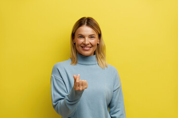 Positive Woman Showing Money Gesture. Portrait of Attractive Positive Blond Girl Smiling and...