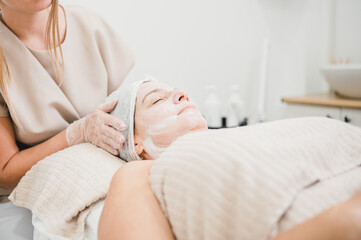 Fototapeta na wymiar woman receiving facial treatment in aesthetic clinic