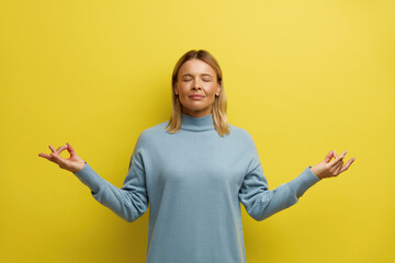 Peaceful Woman Meditating at Studio. Portrait of Attractive Young Girl Relaxing and Doing...