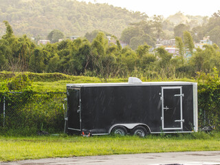 Black covered wagon trailer landscape in green fields on rainy day from puerto rico 