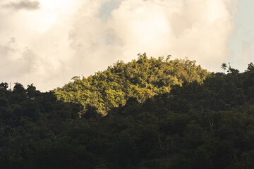 Middle mountain landscape with a sun spot light and clouds above from puerto rico 