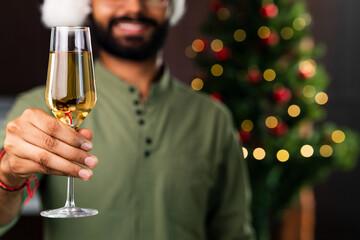 indian man drinking alcohol at home Christmas tree lights garland background