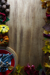 Thanksgiving pumpkins with fruits and falling leaves on rustic wooden table