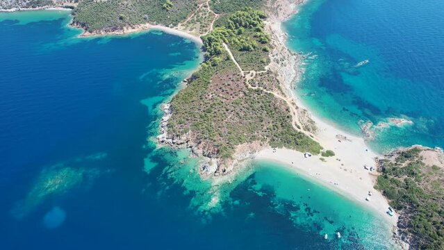 Aerial view of the blue sea water in Sithonia peninsula with green trees in Grece, Europe. Drone shot of a cape