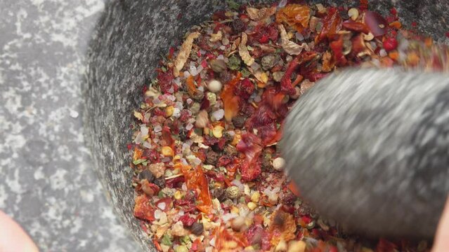The pestle crushes the mixture of peppers
