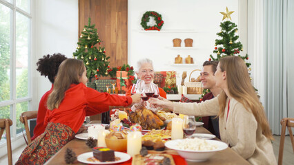 A group of multi ethnic. Portrait of Caucasian and African American black family, woman have a celebration dinner in party on Merry Christmas Eve Xmas on holiday at home or house. People lifestyle.