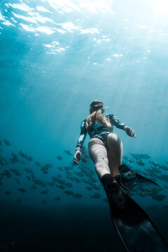 underwater girl who dive in deep ocean with fish