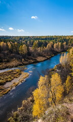 Fototapeta premium Autumn landscape with river, trees, grass and blue sky