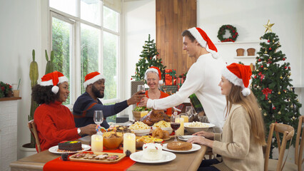 A group of multi ethnic. Portrait of Caucasian and African American black family, woman have a celebration dinner in party on Merry Christmas Eve Xmas on holiday at home.People lifestyle. thanksgiving