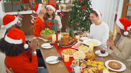 A group of multi ethnic. Portrait of Caucasian and African American black family, woman have a celebration dinner in party on Merry Christmas Eve Xmas on holiday at home.People lifestyle. thanksgiving
