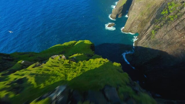 Aerial Tilt Up Shot Of Natural Rock Formations In Sea, Drone Descending On Sunny Day - Faroe Islands, Denmark