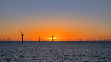 Fototapeta na wymiar Beautiful night offshore with nice clouds around. Wind park.