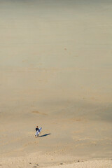 surfer walking on the beach